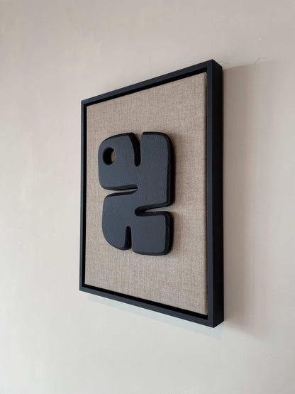 Canvas Noa artwork with anthracite black frame on plant-based material background.