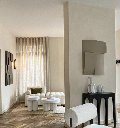 Modern art installation in a contemporary living room setting with neutral furnishings.