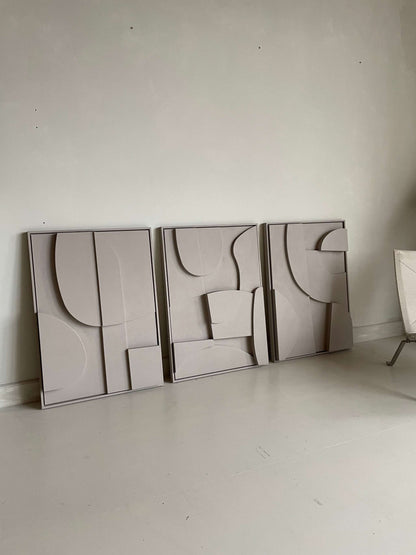 Three abstract handmade art pieces with geometric designs, featuring a sand-textured surface and eco-paint finish, made from biodegradable PLA material.