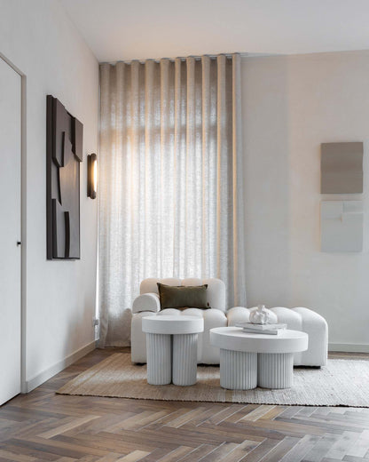 Contemporary living room with white furniture and artistic wall decor.