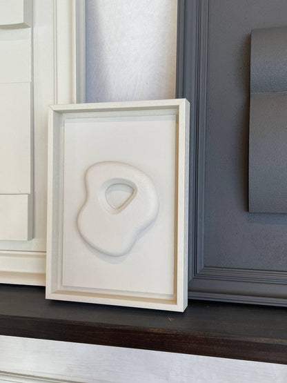 Organic Stone artwork by Edith Beurskens, made of biodegradable PLA with sand texture, in Shadow White frame.