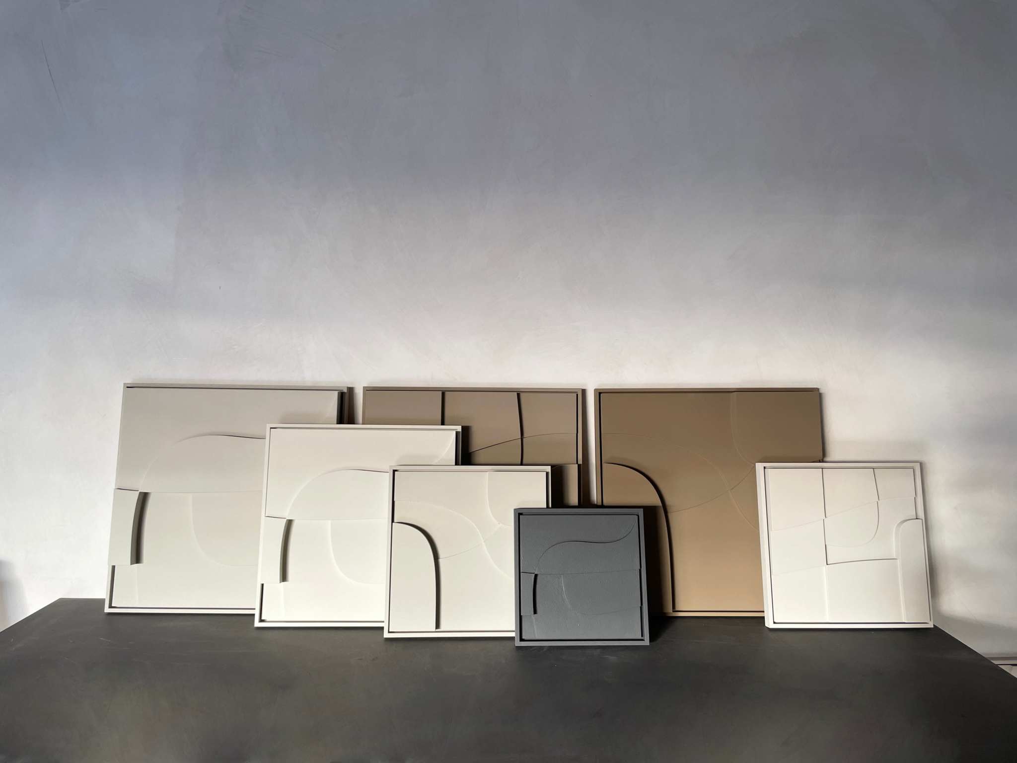 Hand-made 3D art pieces with sand texture finish, customizable colors, displayed on a surface.